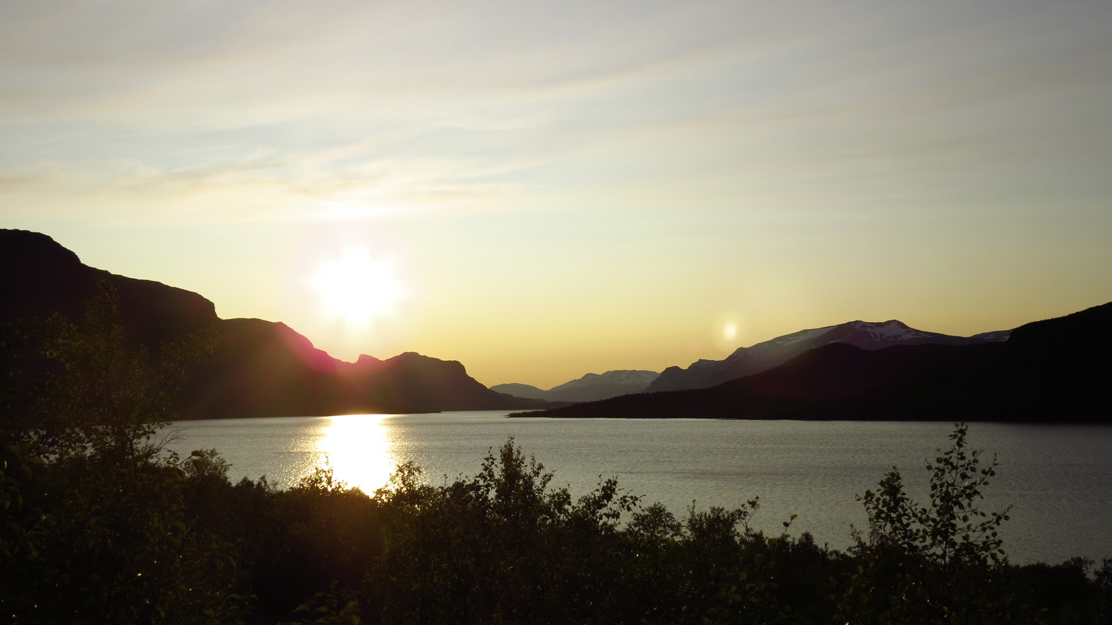 Panorama di un lago con montagne al tramonto