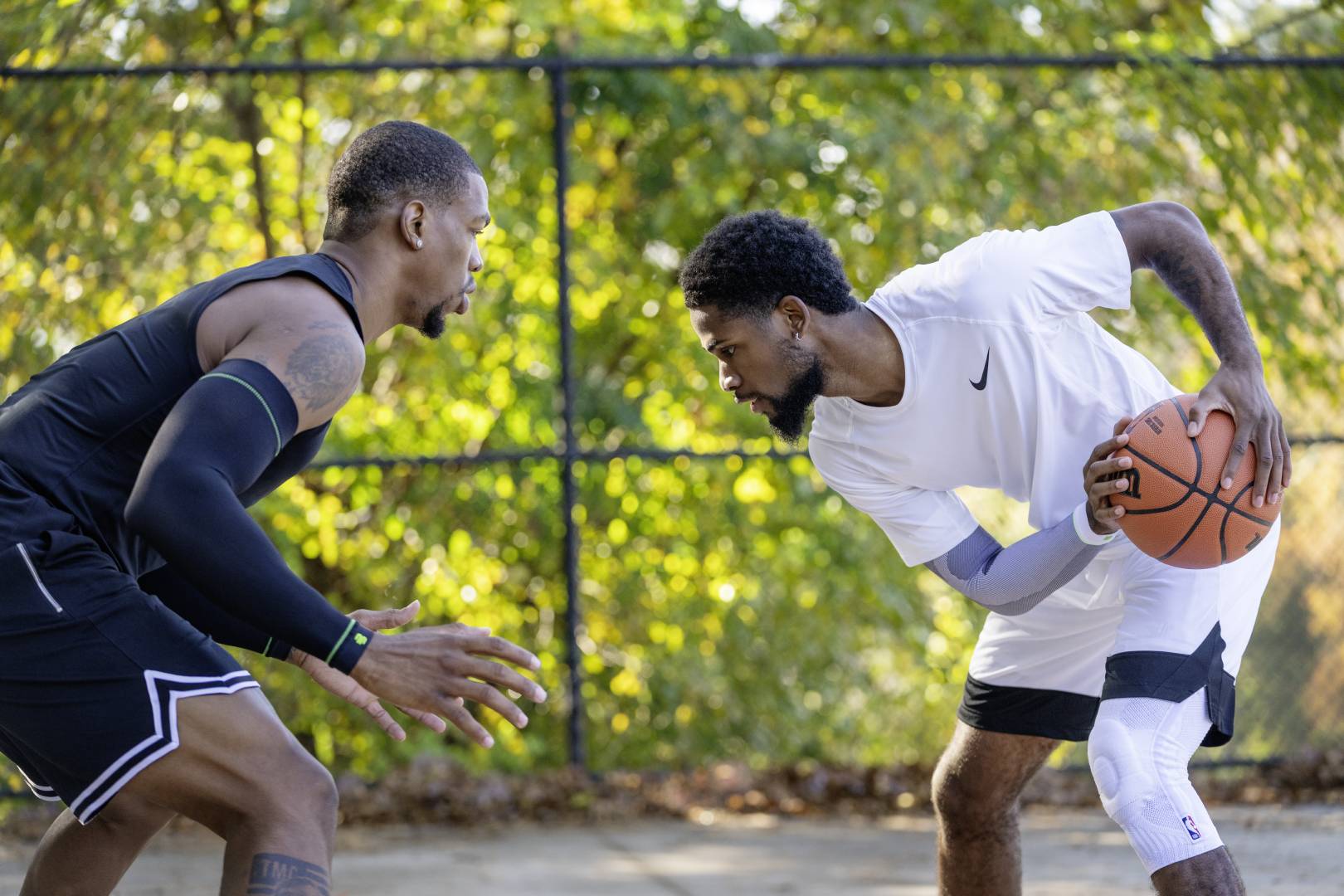 Streetball Player in White Game Clothes cerca di giocare al suo avversario in Black Game Clothes