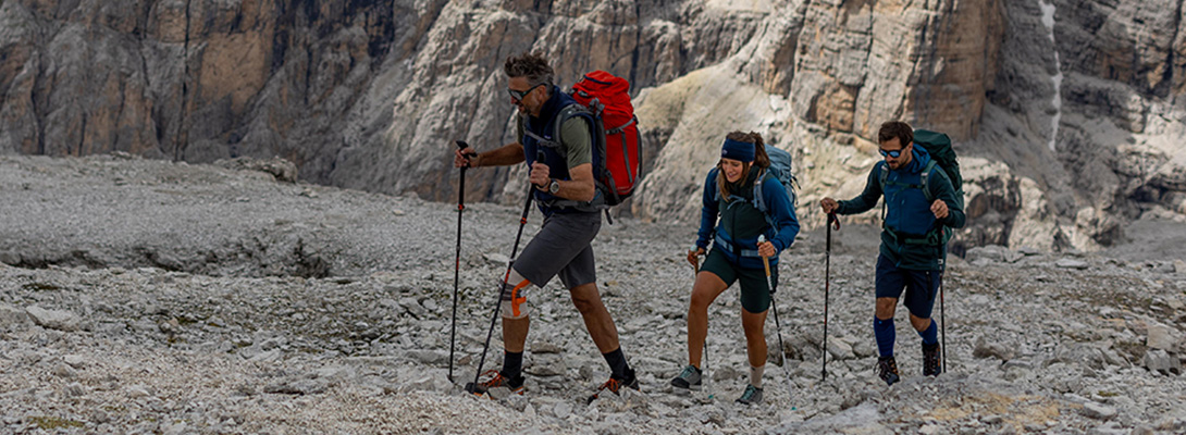 Tre arrampicatori, il primo indossa una ginocchiera da esterno