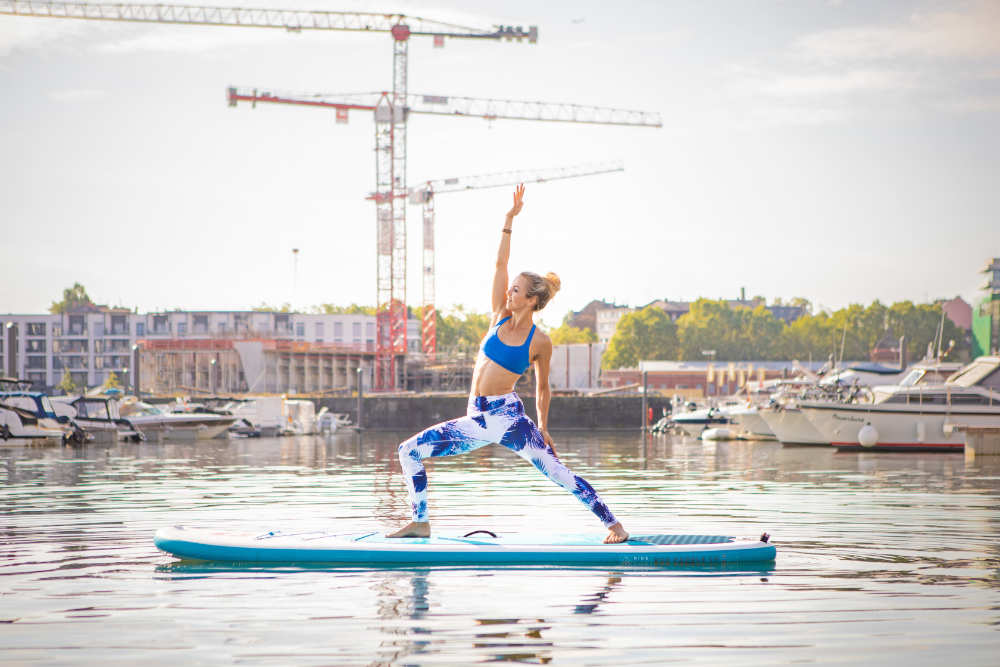 La donna fa yoga sull'acqua: in piedi sulle sue mani sulle sue mani