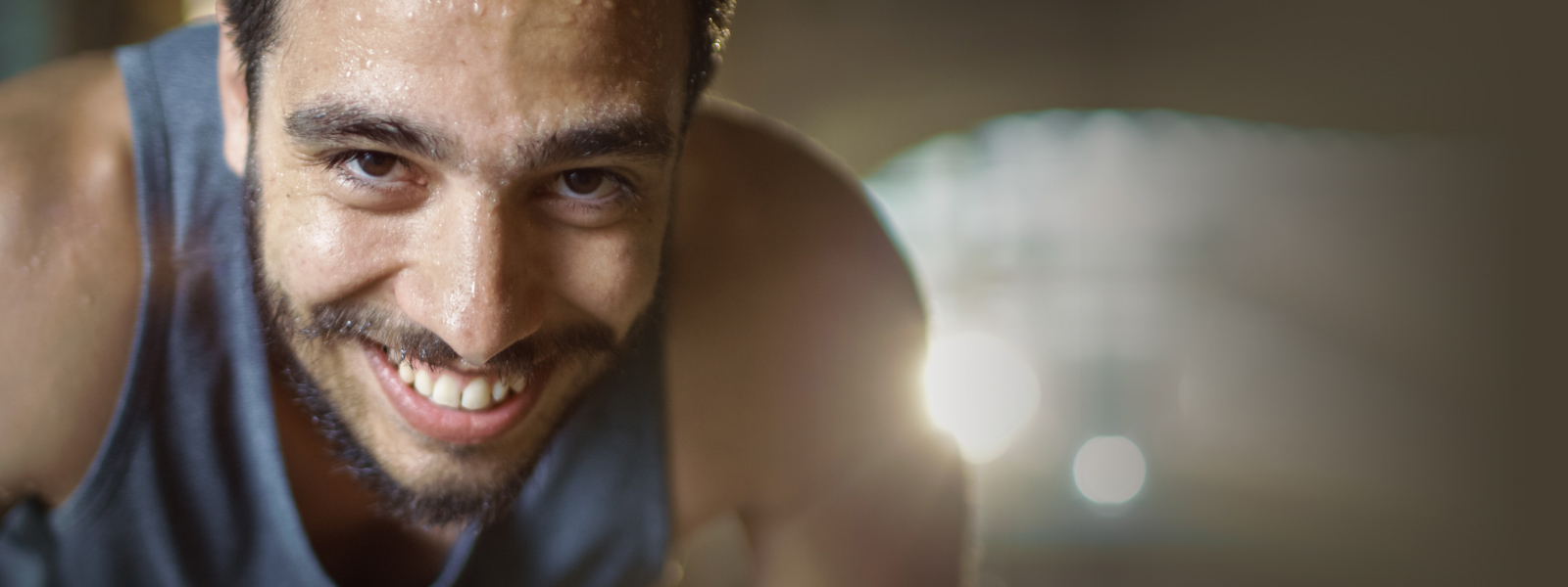 L'uomo sportivo con la barba sembra sorridere e sudare lo spettatore