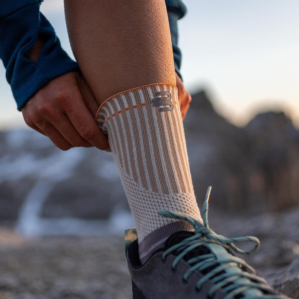 Persona che indossa una calza outdoor traspirante e antiscivolo, perfetta per escursioni e alpinismo.