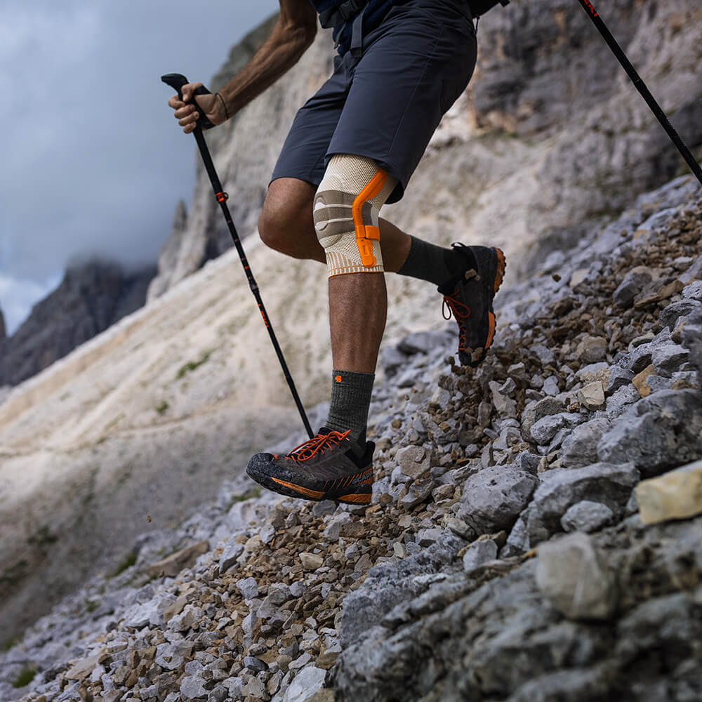 Persona che indossa un tutore per ginocchio outdoor durante un'escursione in montagna